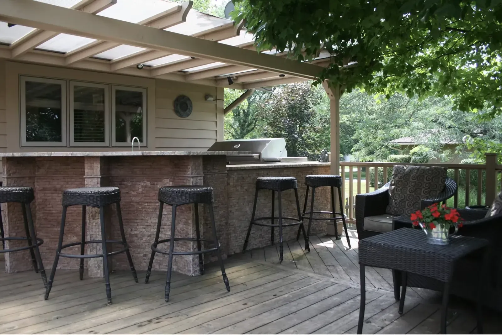 Outdoor kitchen and bar seating under the pergola