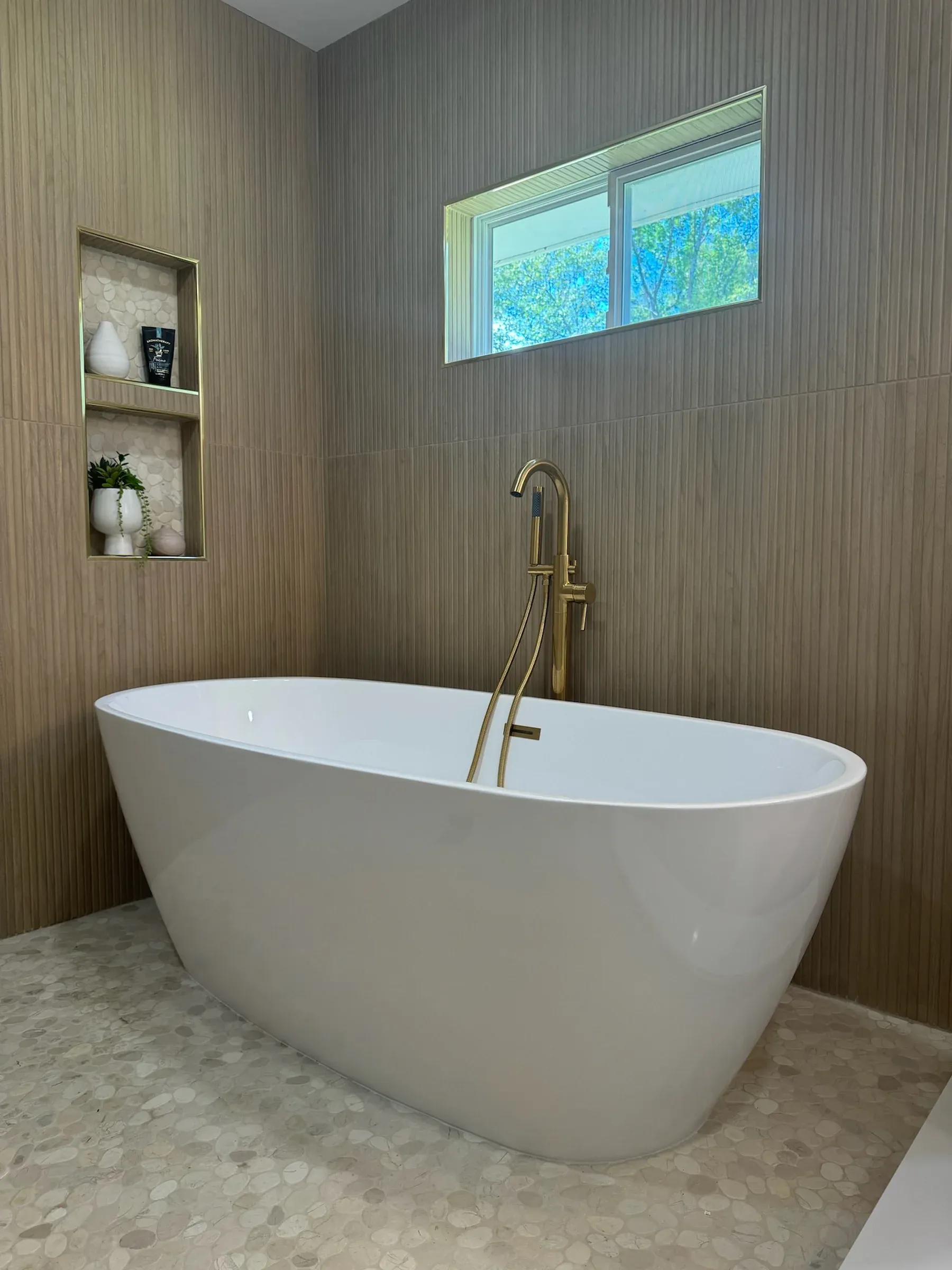 Luxury bathroom remodel with freestanding tub and gold fixtures